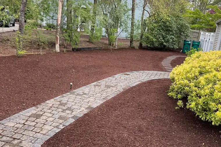 Fresh mulch beds along a cobblestone walkway
