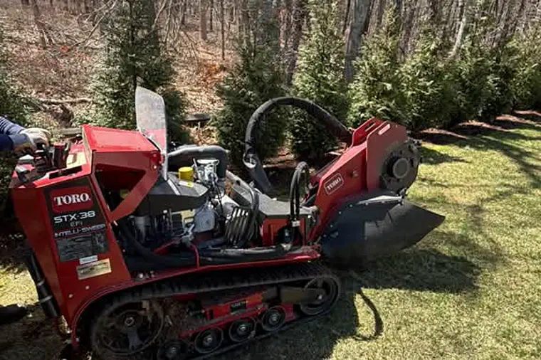 Track stump grinder working on a Cape Cod lawn